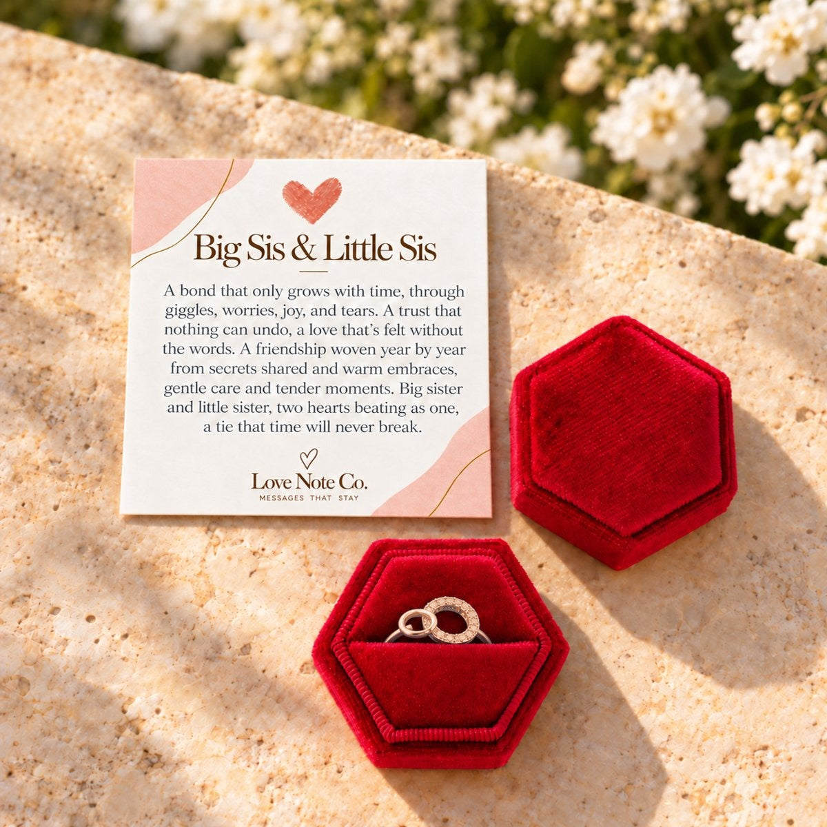 Big Sis and Little Sis ring in its open gift box beside the card